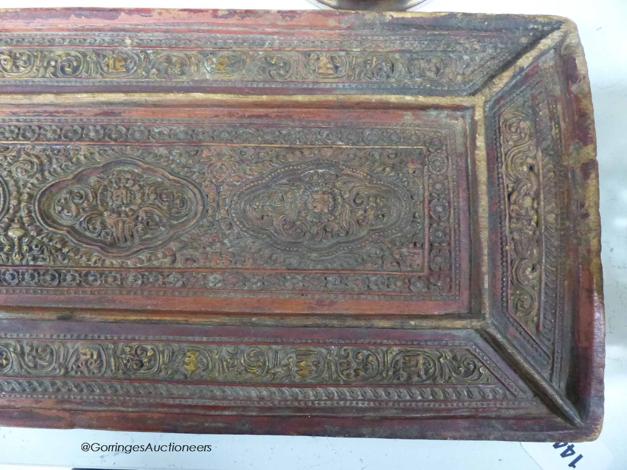 A 15th/16th century Tibetan carved and lacquered wood cover for a sutra box, 72 x 24cm